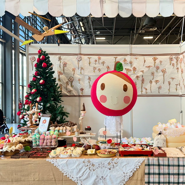 真ん中にリンゴのキャラクターの人形。クリスマスの風景。