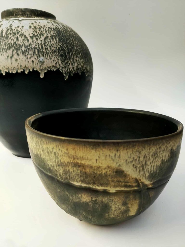 un bol noir et blanc et une vase noir et blanc derrière